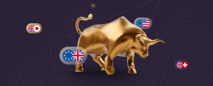 A bull adorned with flags stands next to another bull, which is playfully interacting with a smaller bull.