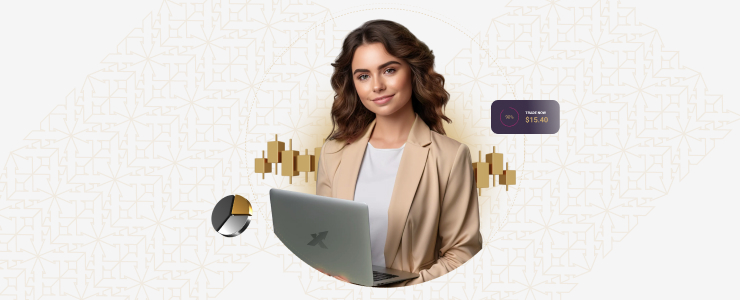A woman is seated at a table, using a laptop while holding a credit card in her right hand.