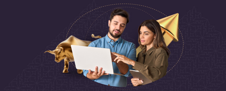 Two people examining a laptop displaying a bull and a gold bull, engaged in a discussion about the images.