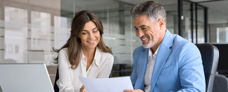 A man and woman review a document, engaged in technical analysis of market trends and trading strategies.
