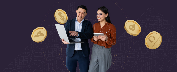 A man and woman hold a laptop and a gold coin, engaged in market analysis and trading strategies for financial indices.